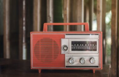 An old-fashioned radio rests on a wooden table, evoking nostalgia and symbolizing the link between hearing.
