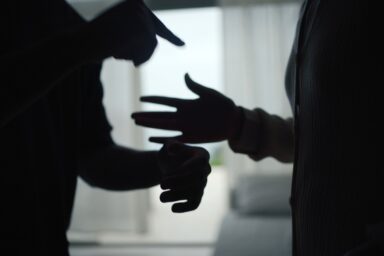 Silhouetted hands of two people in a heated argument, illustrating the tension of a domestic conflict.