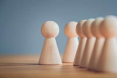 A row of wooden figurines arranged neatly, showcasing their intricate designs and craftsmanship.