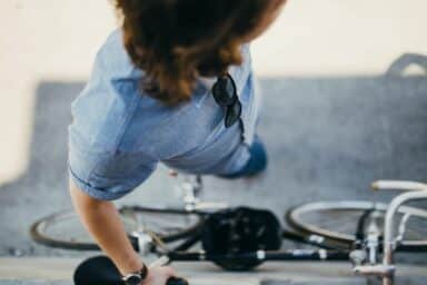 An overhead view of a person in a blue shirt standing with their bicycle on a city street, representing schizophrenia treatment.